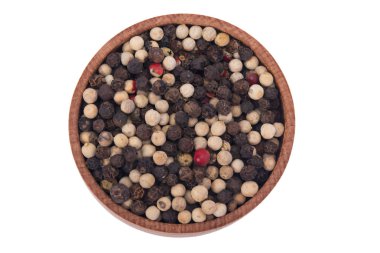 Beyaz bir arka plan üzerinde ahşap bir kap içinde çok renkli karabiber