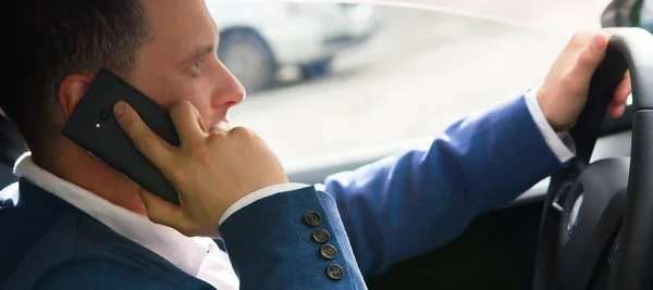 Мужчина в машине разговаривает по телефону со страховой компанией — стоковое фото