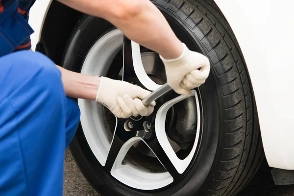 bir İngiliz anahtarıyla, bir tekerlek somun vida açılmış bir motorlu araç tekerlekleri değiştirilmesi için bir ana