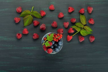 Ahududu ve bir plaka üzerinde bir yazıt için koyu renk arka plan yer orman meyveleri ile