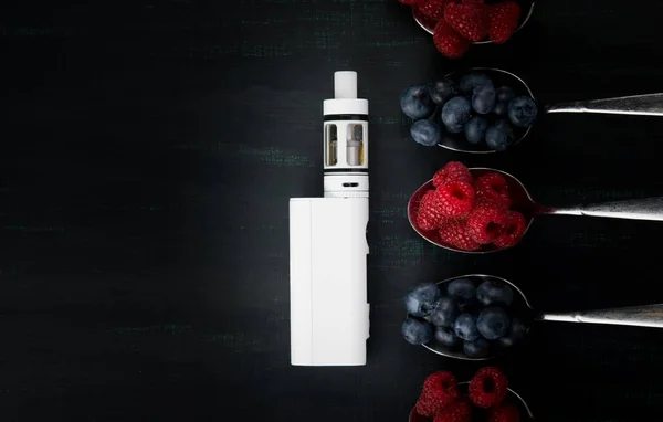 Vit elektronisk cigarett på svart bakgrund, med olika smaker av bär på det — Stockfoto