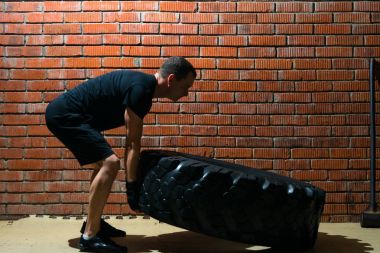 büyük bir tekerlek, bir tuğla duvar arka plan ile spor çalışmaları