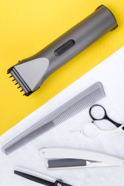 makas yanında sarı bir arka plan üzerinde beyaz bir havlu üzerinde jilet yalan