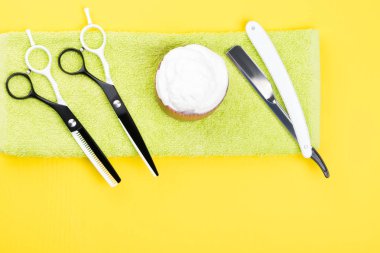 makas yanında sarı bir arka plan üzerine bir havlu üzerinde jilet yalan