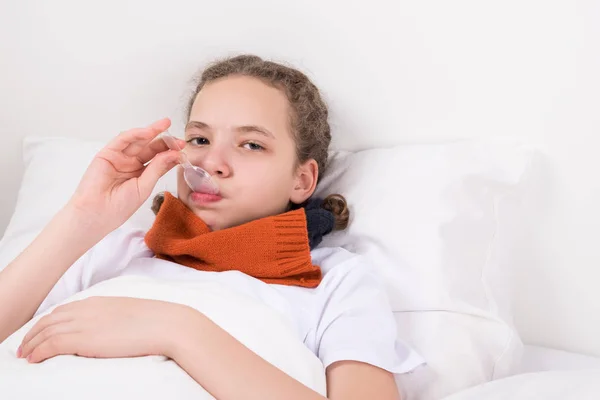 Mädchen Auf Dem Bett Nimmt Medikamente Gegen Halsschmerzen — Stockfoto
