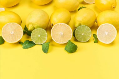limon ve limes yeşil yaprakları sarı bir arka plan ile