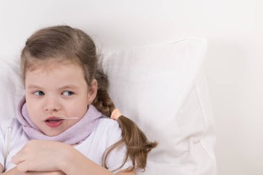 Kız hasta ve ilaç, bir kaşık ile sağ yatakta yatan görünüyor