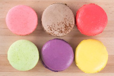 Macaron altı farklı renkleri ve tatları, ahşap oyun tahtası