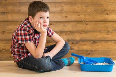 yavru kedi ve düşünüyor, ahşap duvar arka planı için tuvalet tarafından oğlan oturuyor