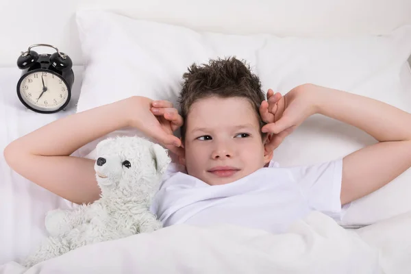 Yatakta Yatan Çocuk Alarmı Bell Onun Kulaklarını Kapatır — Stok fotoğraf