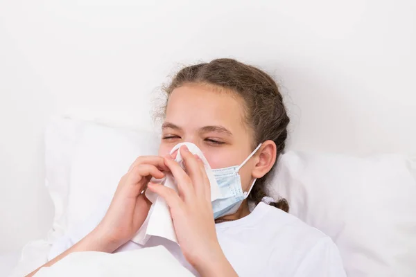 白色床上的女孩用手帕标记鼻涕 — 图库照片