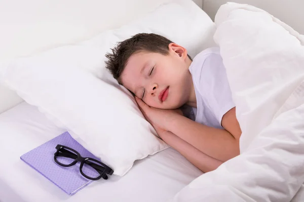 Çocuk Üzerinde Beyaz Uyuyor Yatağım Sonraki Kitap Gözlük — Stok fotoğraf