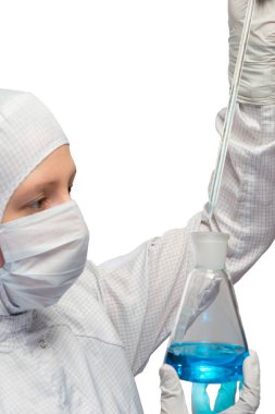 maske ve beyaz koruyucu giysi bir kadın beyaz bir şişe mavi bir sıvı ile deneyler yapar