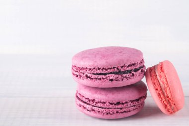 gri arka plan üzerinde 3 çok renkli macaron kurabiye