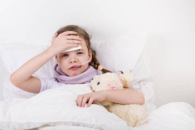 küçük kız hastalandı ateşi gül, o hasta başına elini tutar oyuncak köpek hugs