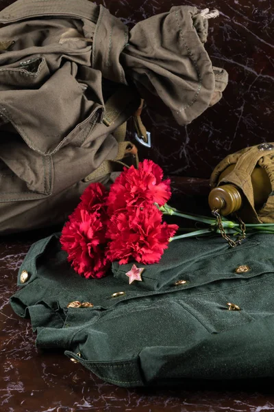 military uniform bag and flowers, concept for greeting, victory card