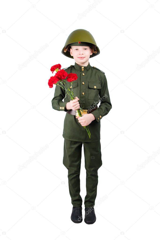 boy stands in military uniform and helmet, with carnations in hands, on white background