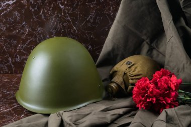 Askerî şeyler ve bir mermer levha, Savaş Anıtı kırmızı çiçekler