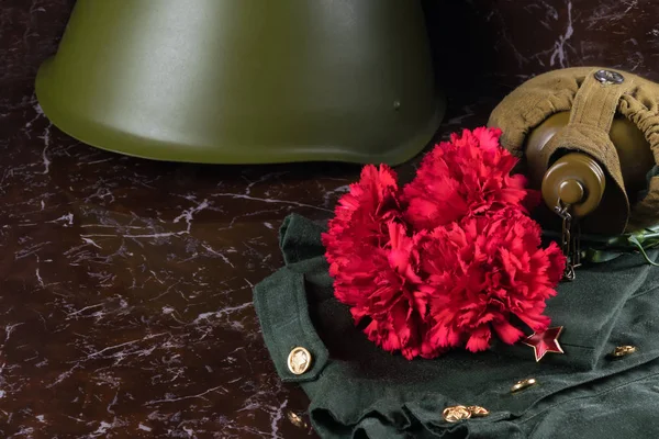 military things with a bouquet of red flowers on the background of a marble slab