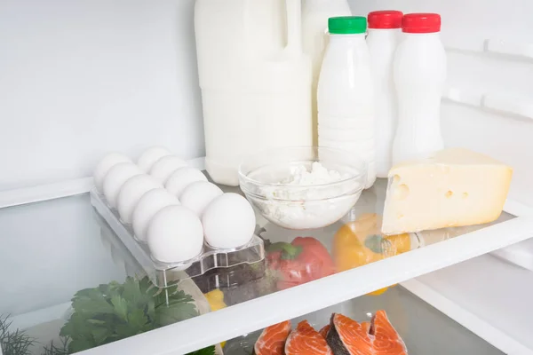 on the shelf in the refrigerator are dairy products and cheeses