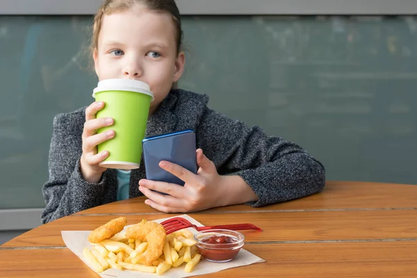 Kleines Mädchen Isst Leckere Knusprige Pommes Und Trinkt Tee Aus — Stockfoto