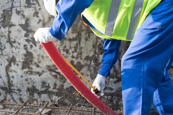 Budowniczy Rękawiczkach Mierzy Długość Czerwonej Rury Oświetlenia Ulicznego — Zdjęcie stockowe