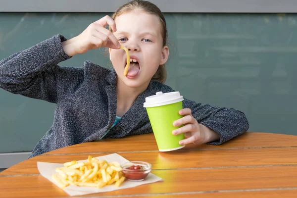 Mädchen Isst Kartoffeln Mit Ketchup Und Trinkt Tee Aus Einem — Stockfoto