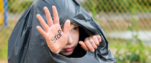 Uma Criança Senta Saco Lixo Preto Mostra Sua Mão Parar — Fotografia de Stock