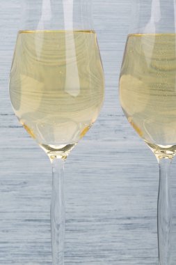 Gri arka planda köpüklü şarap ile dolu iki bardak.