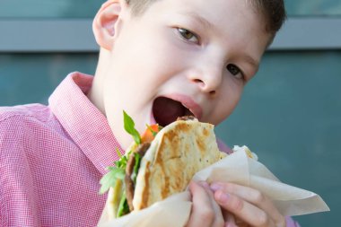 Yakın plan, çocuk fast food ve hamburger yiyor.