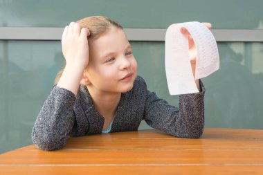 Restoranda bir masada oturan kız, öğle yemeği için uzun bir çeke şaşırır.