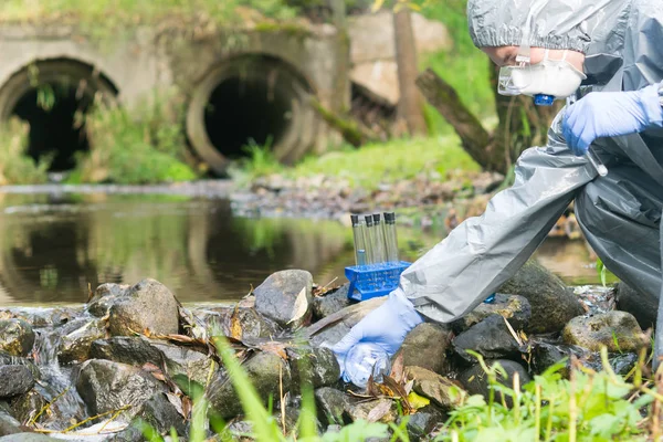 Muž Speciálním Ochranném Oděvu Masce Vtahuje Vodu Řeky Baňky Vypouštění — Stock fotografie