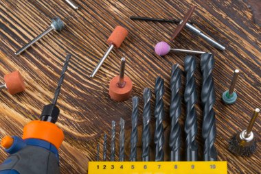 Yakın plan, kabartmalı oymalar, her boyutta matkapların yanında, koyu ahşap bir arka planda.