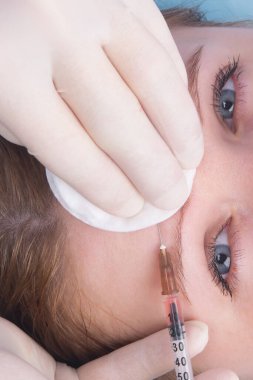 Kozmetoloji, steril eldivenli eller, ön taraftan bir kadına güzellik enjeksiyonu yap, yakın plan.