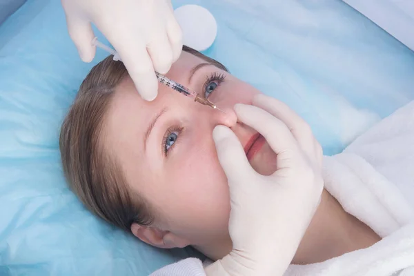 cosmetology, injection into the nose of a woman, for future correction