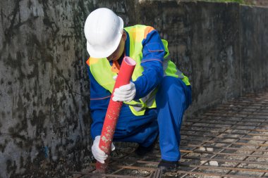 Erkek müteahhit, iletişimi plastik bir boruyla sağlıyor.