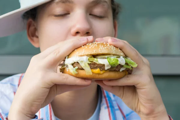 Chica Sosteniendo Una Gran Hamburguesa Sus Manos Muerde Cerrando Los — Foto de Stock