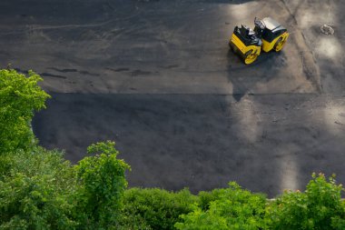 Siyah asfalt ve yeşil ağaçların arka planına karşı, yolu yumuşatmak için ulaşım, buz pateni pisti, yazıtlar için bir yer var.