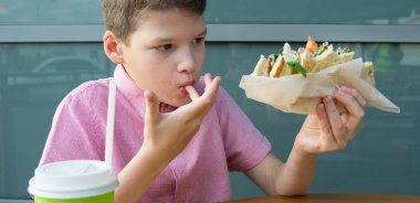 Yakın plan, masada oturan ve fast food yiyen bebek, Big Burger.