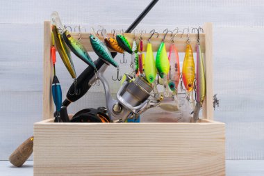 Balıkçılık için bir takım eşyalar, tahta bir kutuda, arka planda.