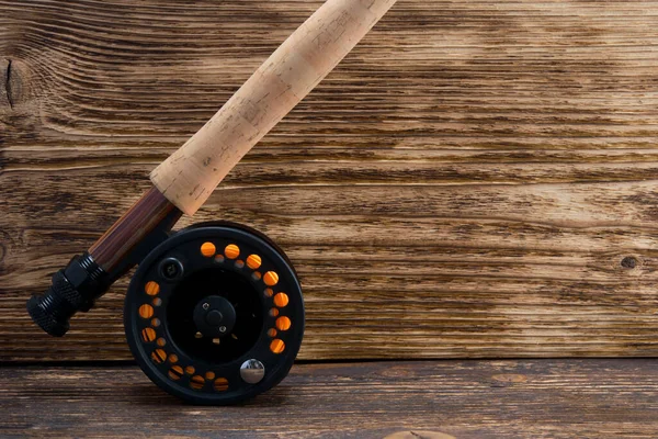 fishing line and fishing rod handle, on a dark wooden background, on the right there is a place for the inscription