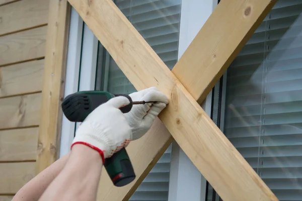 a worker drills the Windows of a house from thieves when moving to another address, close-up