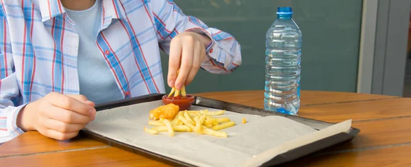 셔츠를 어린이가 식탁에 패스트푸드를 닭고기를 곁들인 감자튀김 — 스톡 사진