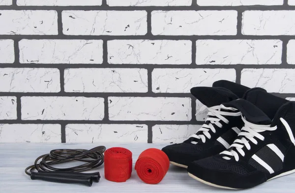 在白色砖墙的背景下 有训练用的运动器材 保护拳击手的绷带 跳绳和运动鞋 — 图库照片
