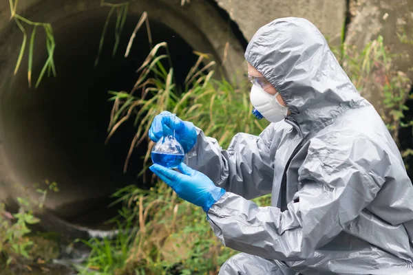 Man Skyddsdräkt Och Mask Håller Sin Hand Kolv Med Blå — Stockfoto