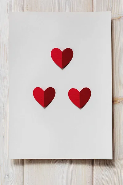 Metin için yer ile ahşap arka plan üzerinde kırmızı kağıt Kalpler.