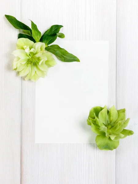 Beyaz çiçekler ve ahşap arka plan üzerinde beyaz sayfa.
