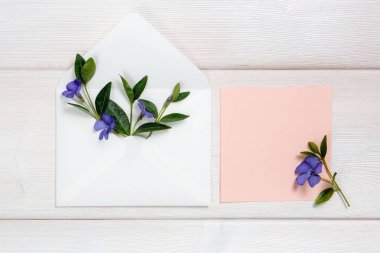 Zarf ve pembe sayfasında ahşap arka plan üzerinde renkli yaz çiçek.