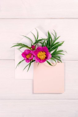 Zarf ve pembe sayfasında ahşap arka plan üzerinde renkli yaz çiçek.