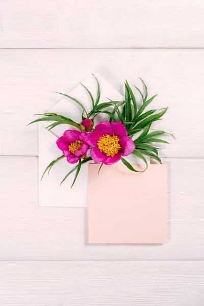 Zarf ve pembe sayfasında ahşap arka plan üzerinde renkli yaz çiçek.